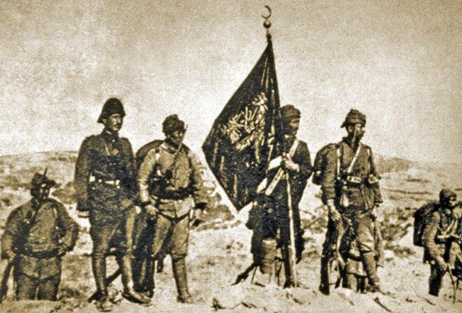 Çanakkale muharebelerinde Arıburnu’na dikilen57. Alay’ın gazi sancağı ve muhafızlarını gösterenbir fotoğraf (AA, I/4 [2. seri, 1949], s. 56)