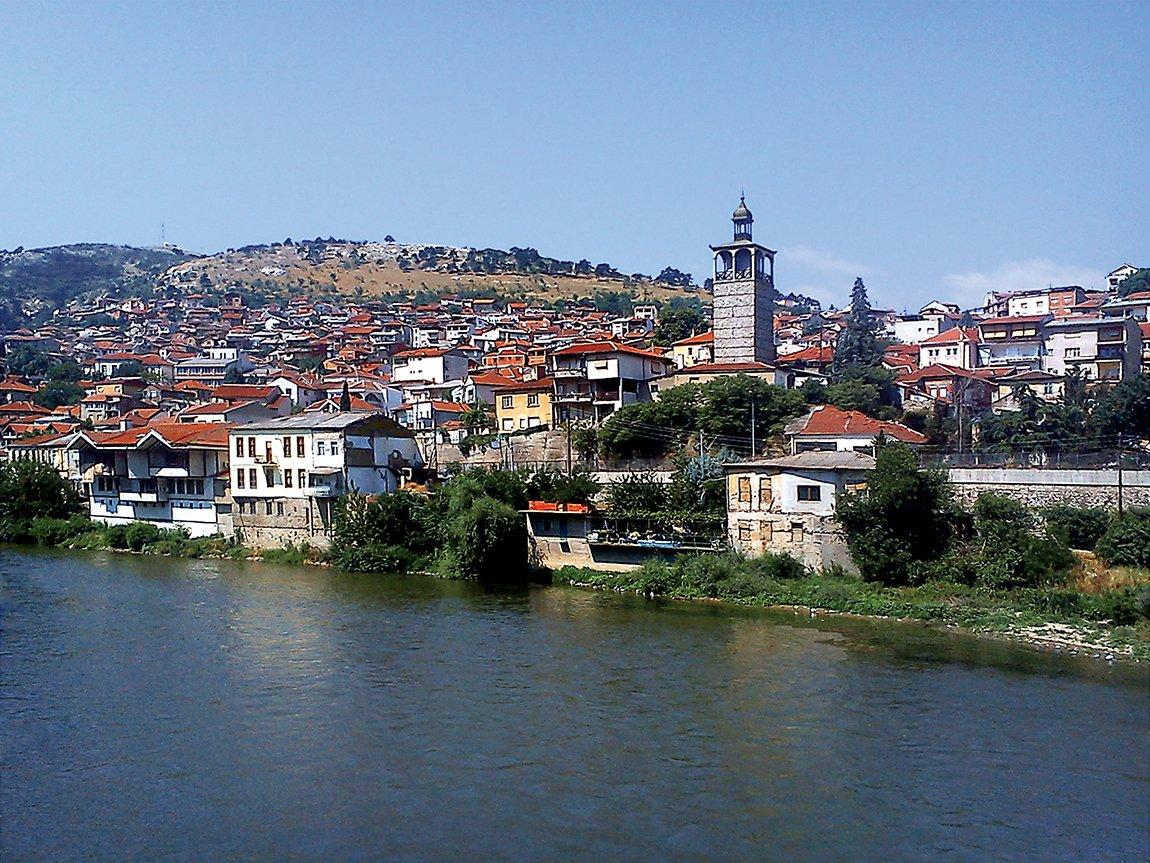 Köprülü’de Vardar nehrinin kıyısındaki eski evler ve saat kulesi